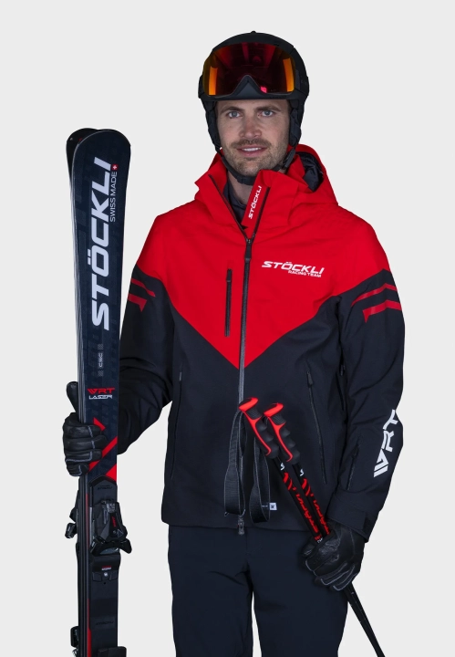 Model w kurtce STOECKLI WRT, pozujący z nartami, demonstrujący profesjonalny wygląd.