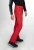 Model w czerwonych spodniach STOECKLI SKI PANT RACE RED, prezentujący krój Slim Fit, widok z boku.