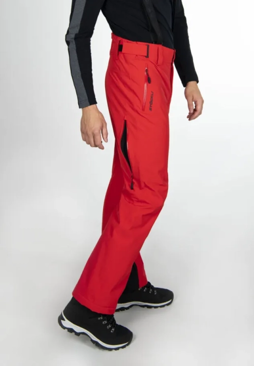 Model w czerwonych spodniach STOECKLI SKI PANT RACE RED, prezentujący krój Slim Fit, widok z boku.