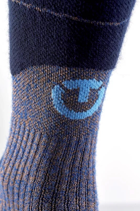 Zbliżenie na wzmocnienie i logo w okolicy łydki skarpety THERM-ic Merino Reflector.
