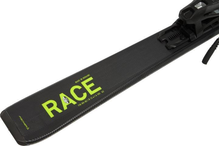 Dynamiczny design nart Fischer RC4 Race JR z widocznym napisem RACE na jaskrawym tle, który nawiązuje do sportowej linii dla dorosłych i motywuje młodych sportowców do rozwijania pasji narciarskiej.